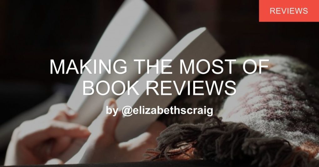 Woman covered in a blanket reading a book.